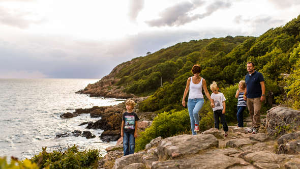 Familj går vid kusten i Kullabergs naturreservat