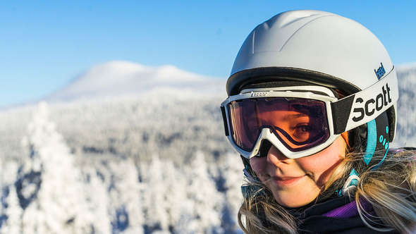 Flicka i skidhjälm på fjäll Flicka i skidhjälm på fjäll