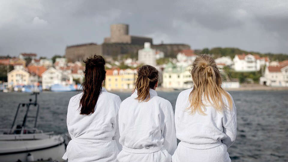 Kvinnor i badrock tittar ut över Marstrand