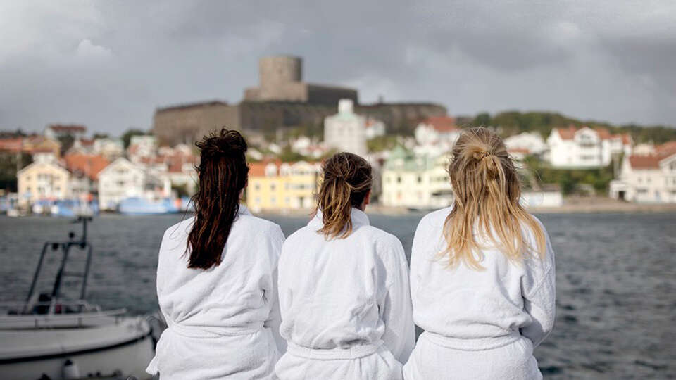 Kvinnor i badrock tittar ut över Marstrand Kvinnor i badrock tittar ut över Marstrand